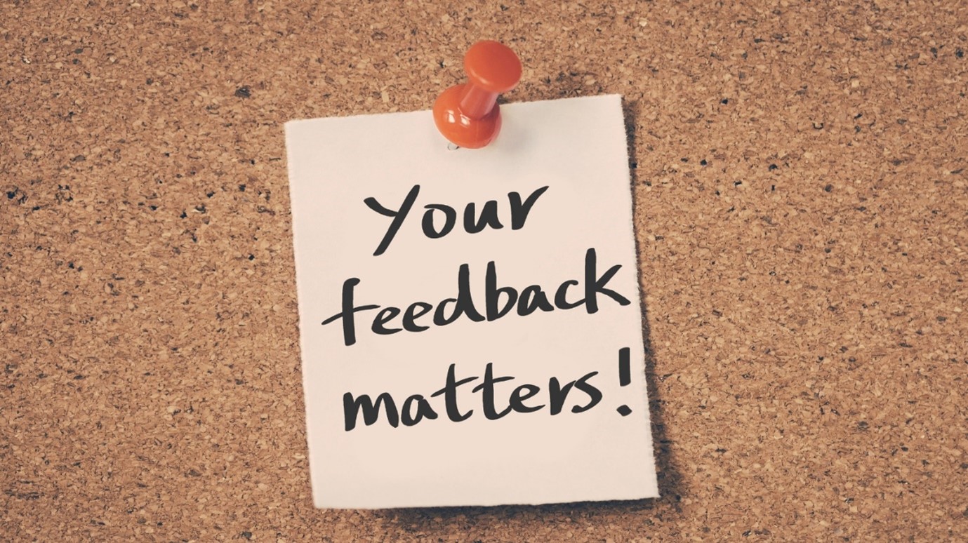 Post-it note pinned to a cork board which reads: "your feedback matters!"