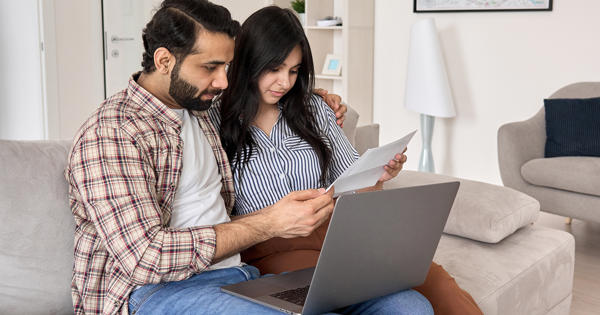 Couple On Laptop Looking At Form