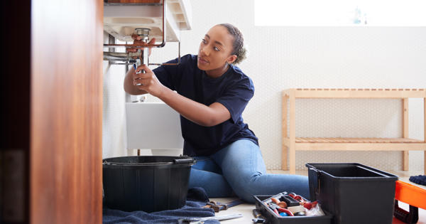 Woman Repairing Sink