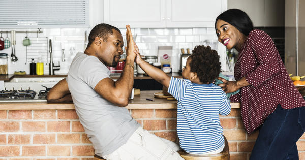 Family High Fiving In Kitchen