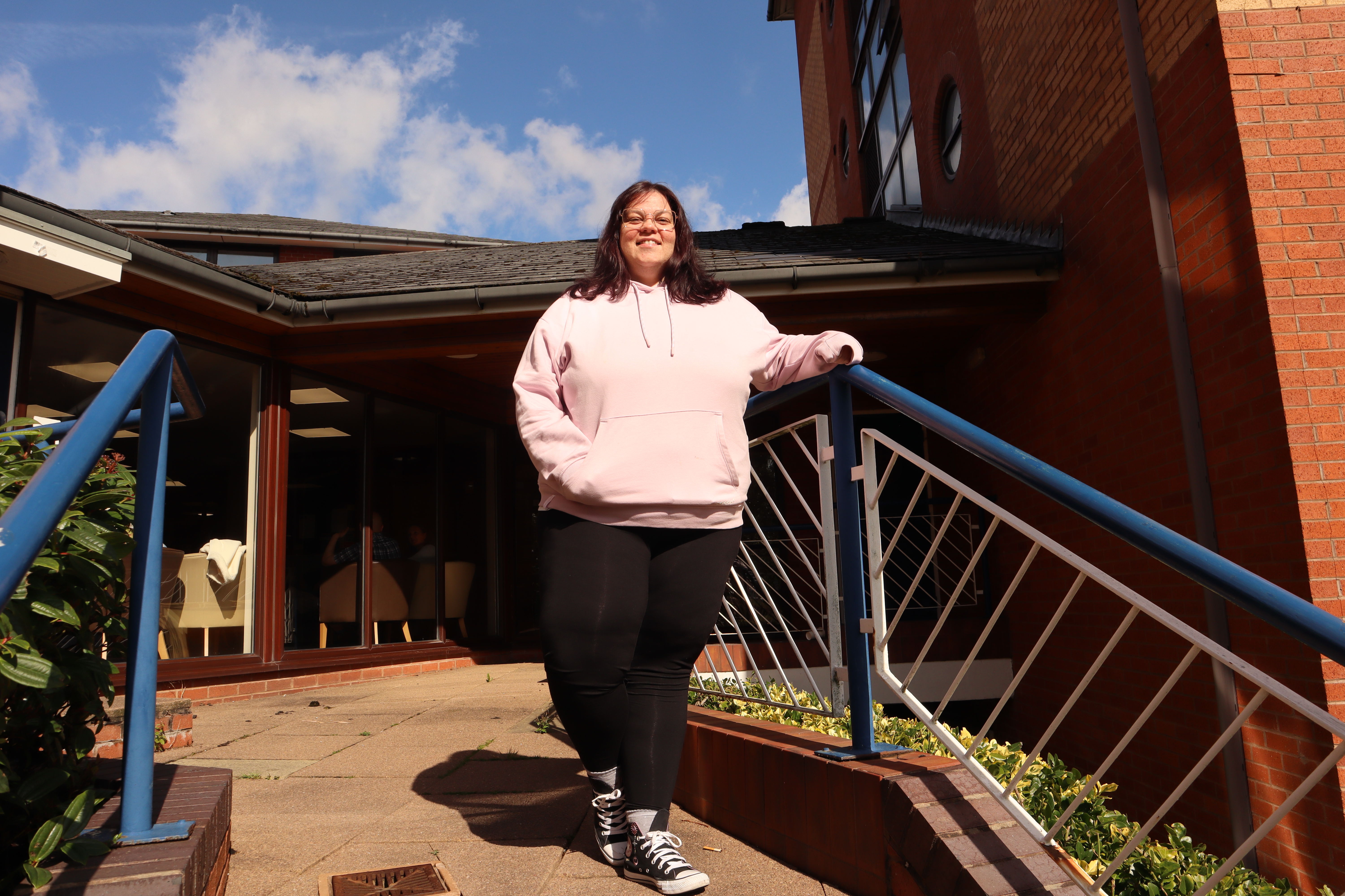 Woman standing at the top of the stairs smiling