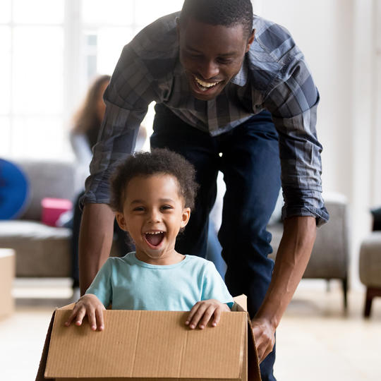 Family Moving In Young Boy In Box