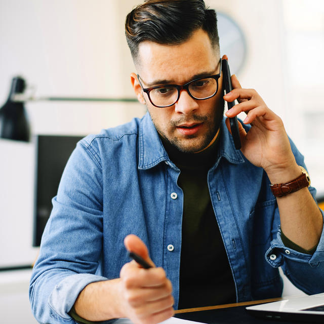 Young Man Speaking To Someone On The Phone Looking Concerned