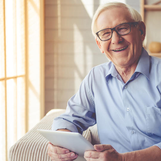 Older Man Happy At Home With Ipad