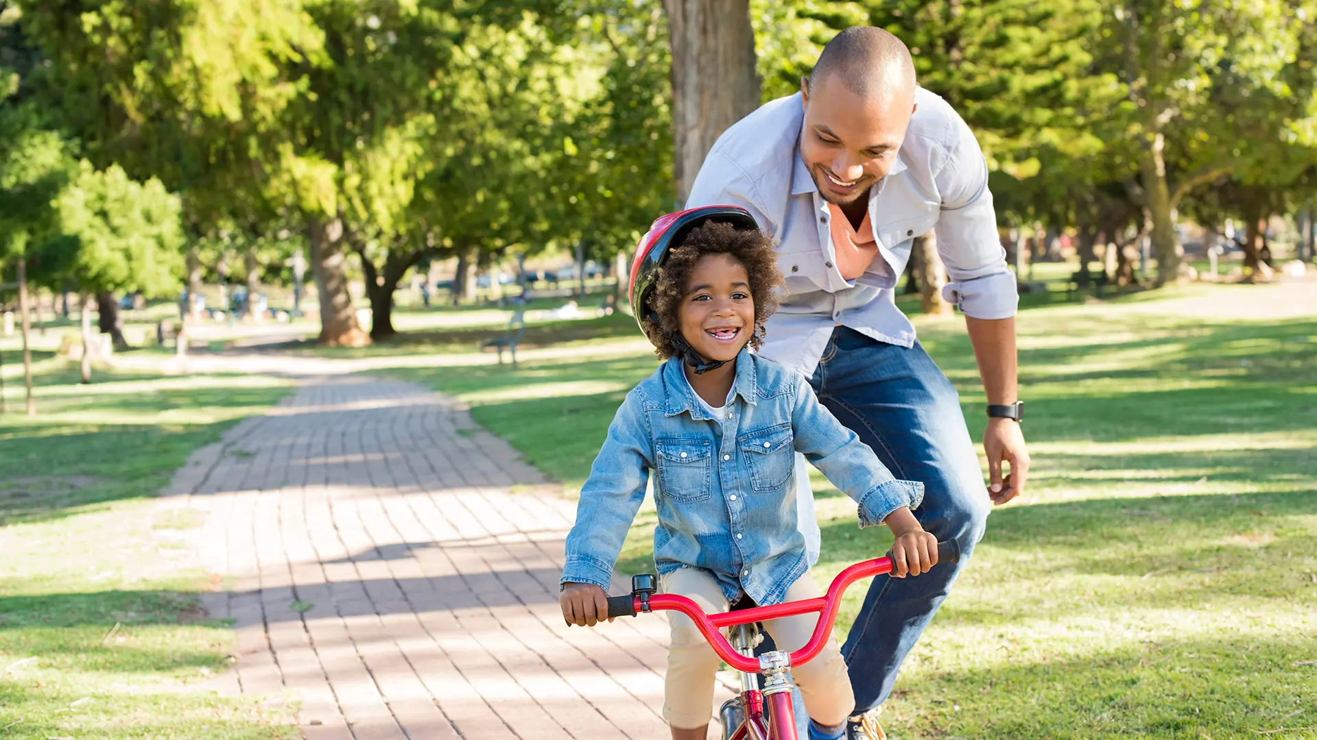 Father Teaching Young Son How To Ride A Bike