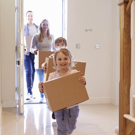 Young Family Moving In Children With Boxes