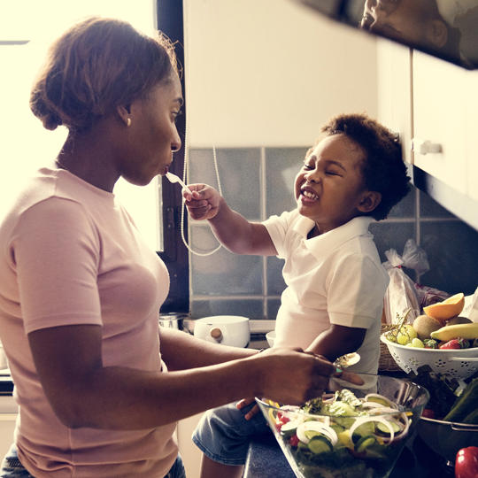 Mother And Young Child Cooking In The Kitchen